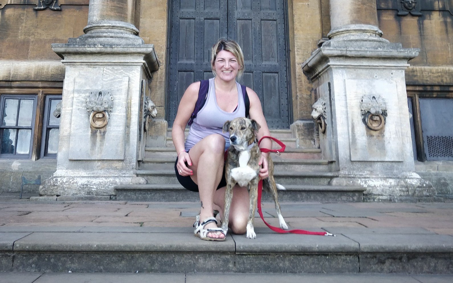 woman with her dog in front of a building