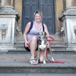 woman with her dog in front of a building