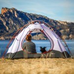 woman and dog in a tent with mountain view