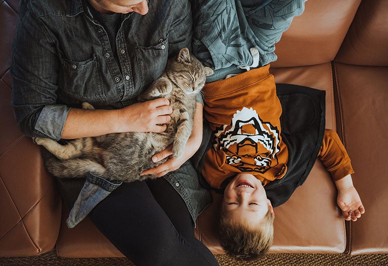 Man and boy with cat on couch