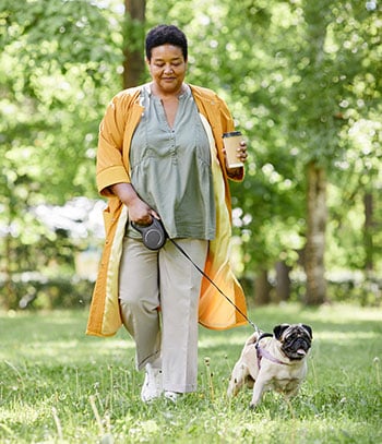 A woman walking a pug