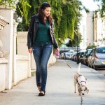 Woman walking a dog in the city.